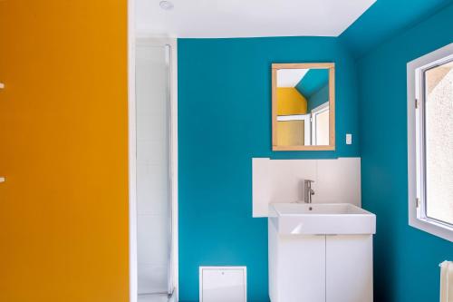 uma casa de banho com paredes coloridas e um lavatório. em Maison de ville en plein centre avec terrasse em Poitiers