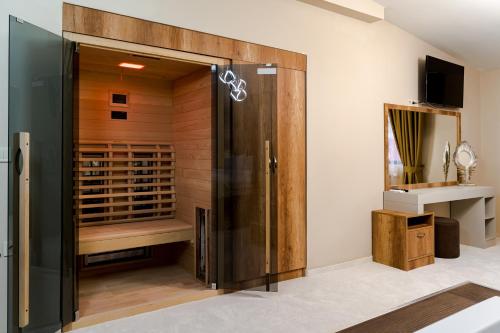 a wine cellar with a glass door and a sink at Cappo suites in Veliko Tŭrnovo