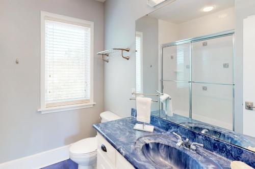 łazienka z błękitną umywalką i toaletą w obiekcie Towering Dunes w mieście Wyspa St. George