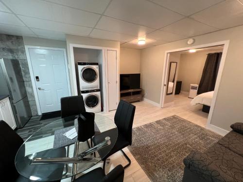 uma sala de estar com uma mesa de vidro e um quarto em Le Centre-Ville em Rouyn