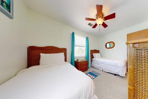 a bedroom with two beds and a ceiling fan at Somerset in St. George Island