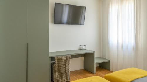 a room with a desk and a television on a wall at Tempo B&B in Vidor
