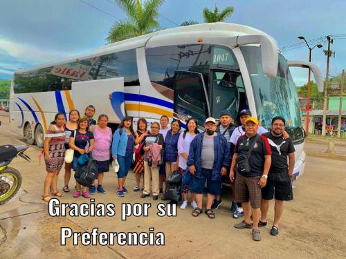 a group of people standing in front of a bus at Hotel Del Valle in El Naranjo
