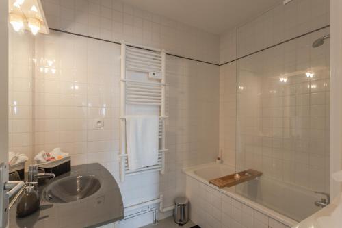 uma casa de banho com uma banheira e um lavatório e uma banheira em The one - Cosy T2 Check-in 24/24 Fibre Parking em Blagnac