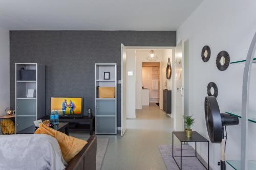 uma sala de estar com uma cama e um quarto com um corredor em The one - Cosy T2 Check-in 24/24 Fibre Parking em Blagnac