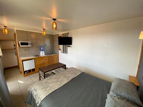 een hotelkamer met een bed en een keuken bij Cabaña Estudio - BBQ Cocina Estacionamiento Wifi in Quintay