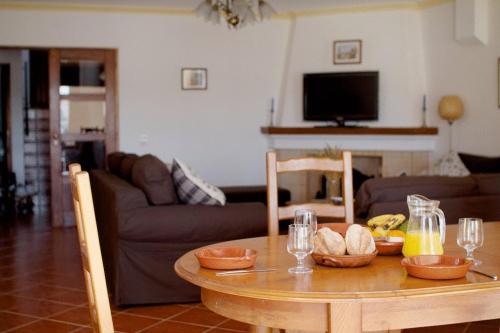 a living room with a table with bowls of food on it at Apartamentos Os Descobrimentos in Burgau