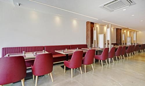 a row of tables and red chairs in a restaurant at Treebo Premium La Orchid, Big Temple in Thanjāvūr