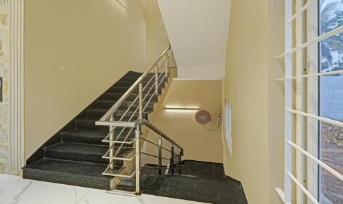 a staircase in a building with a metal railing at Treebo Premium La Orchid, Big Temple in Thanjāvūr