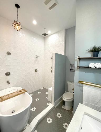 a bathroom with a tub and a toilet and a sink at Sparkling pool home 6-BR Oasis Near Downtown in San Antonio