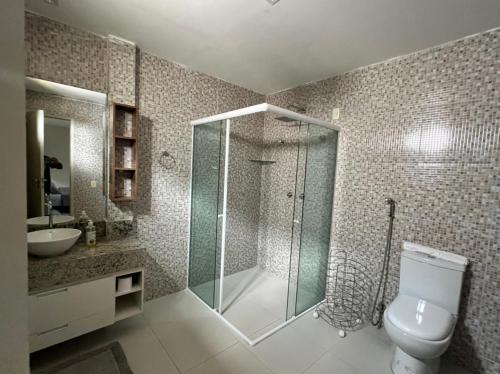uma casa de banho com um chuveiro, um WC e um lavatório. em Cobertura e Flat Tabatinga em Conde