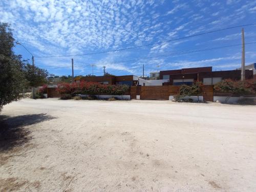 a dirt parking lot with buildings in the background at Cabañas Urmeneta Sur in Tongoy