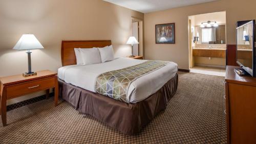 a hotel room with a bed and a bathroom at Best Western Cottonwood Inn in Cottonwood