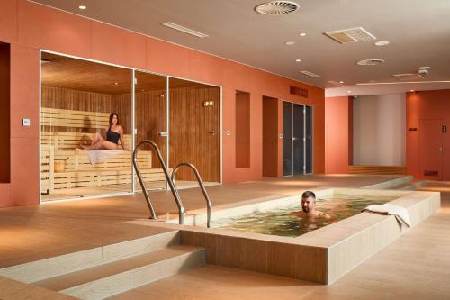 a man in a hot tub in a hotel room at Radisson Blu Resort & Spa in Split