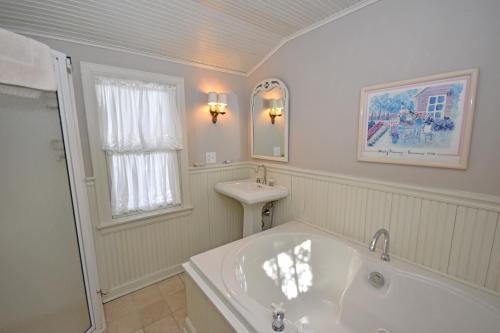 Un baño blanco con bañera y lavabo. en Morning Glory, en Maple City