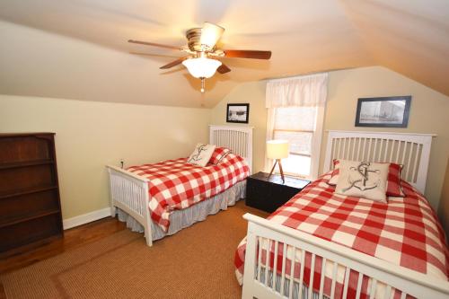 Un dormitorio con dos camas y un ventilador de techo. en Morning Glory, en Maple City