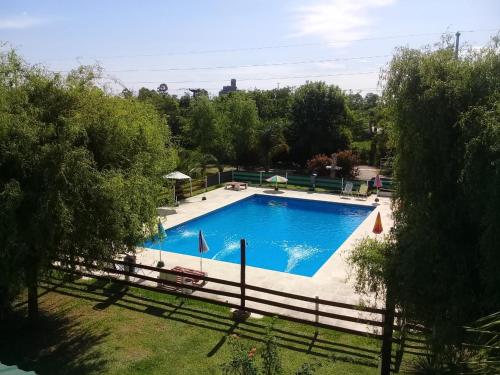 a large swimming pool with a fence around it at Verde y Sol en la Colonia Bungalows y Cabañas in Concepción del Uruguay