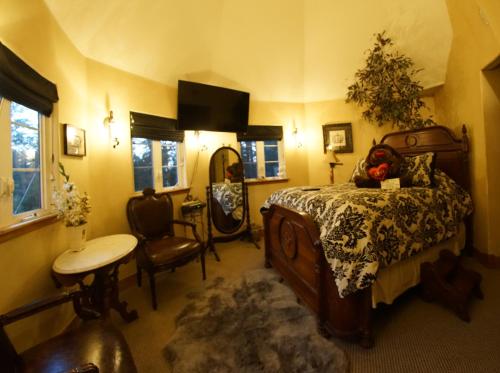 a bedroom with a bed and a desk and a table at FLEUR DE LAC EUROPERAN INn in Lake Arrowhead