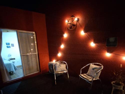 two chairs in a room with lights on the wall at Río Tigris Apart 1 in Tigre