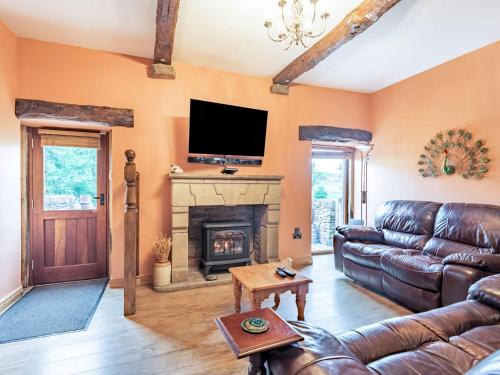 a living room with a couch and a fireplace at Peacock Cottage in Dove Holes