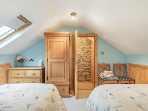 1 Schlafzimmer mit 2 Betten und einer Holztür in der Unterkunft Peacock Cottage in Dove Holes