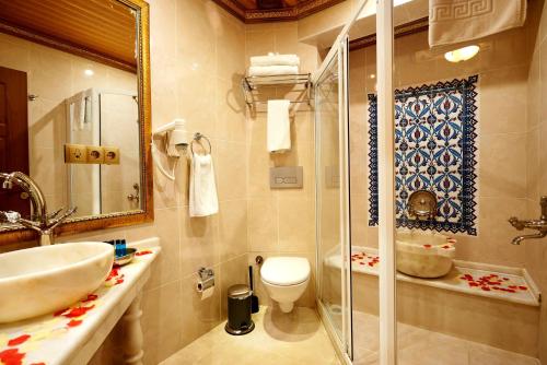 Un baño con ducha, lavabo e inodoro. en Marmara Deluxe Hotel, en Estambul