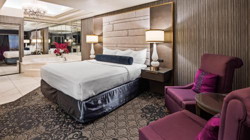 a hotel room with a bed and a bathroom at Abbey Inn Cedar City in Cedar City
