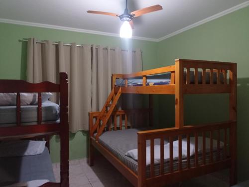 2 Etagenbetten in einem Zimmer mit Deckenventilator in der Unterkunft Vila Caiçara - Praia Grande in Praia Grande