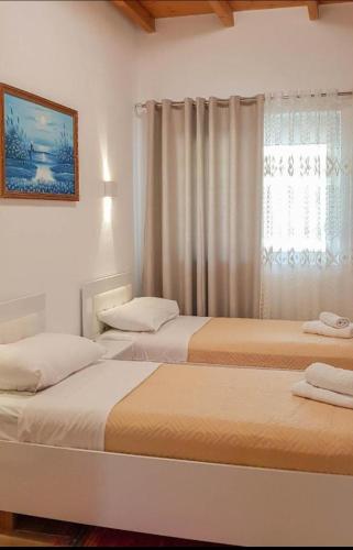 two beds in a room with a window at Villa Goliku in Peshtan