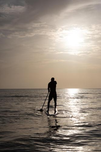 a man is paddle boarding in the water at Cucu Hotel El Cuyo in El Cuyo