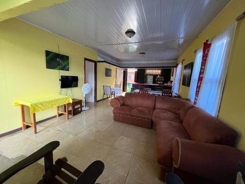 a living room with a brown couch and a table at Casa Artavia in Tortuguero