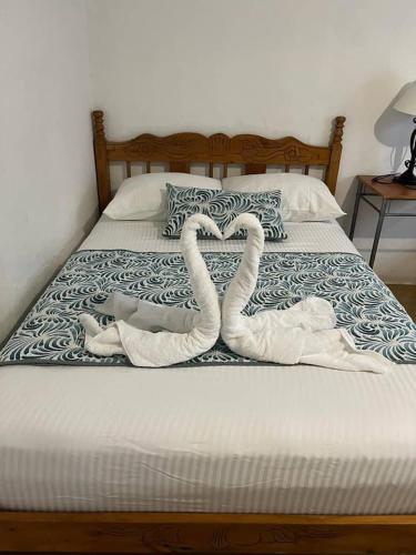 トルトゥゲーロにあるCasa Artaviaのベッド上のハートの形をしたタオル2枚