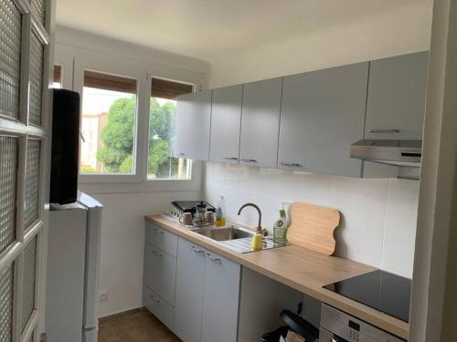 a kitchen with white cabinets and a wooden counter top at Superbe T3 spacieux, lumineux et sans vis-à-vis in Vigneux-sur-Seine