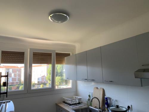 a kitchen with white cabinets and a window at Superbe T3 spacieux, lumineux et sans vis-à-vis in Vigneux-sur-Seine