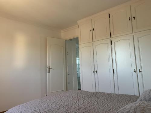 a white bedroom with white cabinets and a bed at Superbe T3 spacieux, lumineux et sans vis-à-vis in Vigneux-sur-Seine