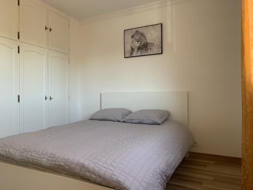 um quarto com uma cama e uma fotografia na parede em Superbe T3 spacieux, lumineux et sans vis-à-vis em Vigneux-sur-Seine