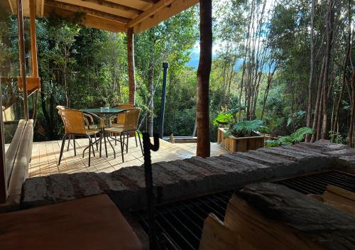 a wooden deck with a table and chairs on it at Cabañas Los Cantos del Chucao in Puerto Varas