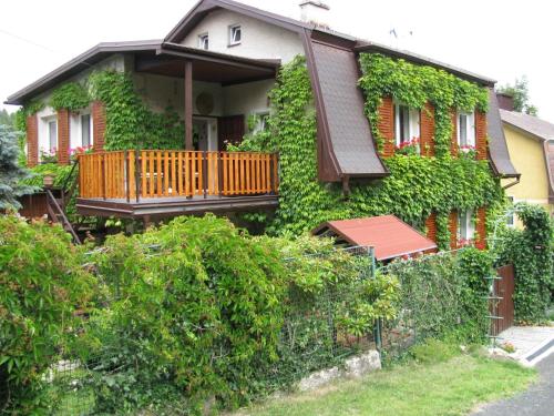 a house covered in green ivy with a balcony at Modern Apartment in Carlsbad with Garden in Karlovy Vary
