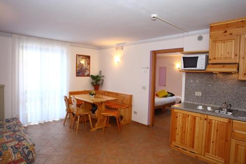 a kitchen and dining room with a table and chairs at Hotel & Residence Montana in Fai della Paganella