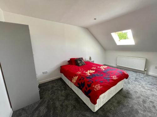 a bedroom with a bed with a red blanket at Layrek London 1 bedroom flat in London