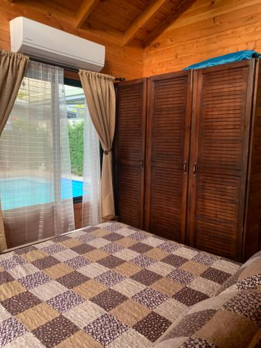 a bedroom with a bed with a checkeredkered bedspread at Pura Vida Cabinita in Uvita