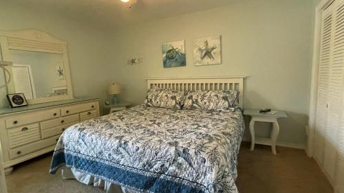 a bedroom with a bed and a dresser and a mirror at Sunny Daze, Desirable Kid Friendly Resort, 3 minute walk to the Beach, Resort Beachside Pool & Restaurant in Panama City Beach