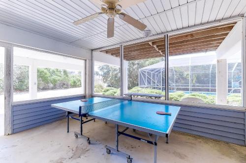 a blue ping pong table in a room with windows at Abbeyfeale in St. George Island