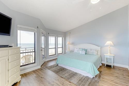 1 dormitorio con 1 cama y balcón con vistas al océano en Ocean Mile H-9, en St. George Island