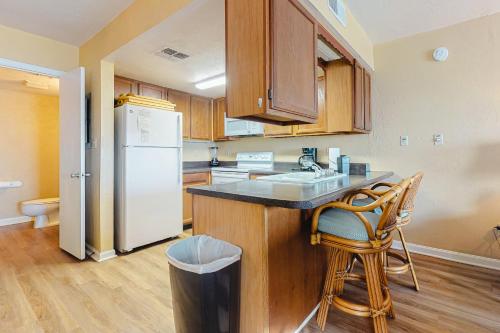 een keuken met een witte koelkast en houten kasten bij Ocean Mile F-1 in St. George Island
