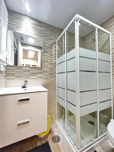 a bathroom with a glass shower and a sink at Ile Atocha Exterior Olivar in Madrid