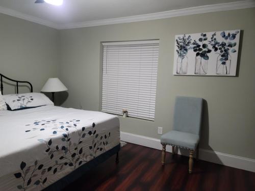 a bedroom with a bed and a window and a chair at Lovely oasis with private swimming pool 4,6,8 f deep in Gulf Breeze