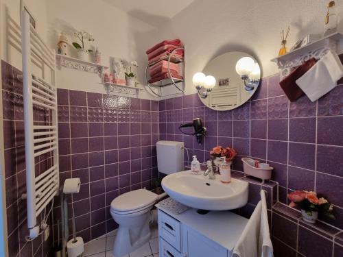 a purple bathroom with a sink and a toilet at Traumblick! Mitten im Wasser, dem Himmel ganz nah! in Schleswig