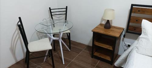 a glass table and two chairs in a bedroom at Las Cabañas del Francés in Vallenar