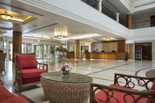a lobby with a table and chairs in a building at Fujairah Rotana Resort & Spa - Al Aqah Beach in Al Aqah